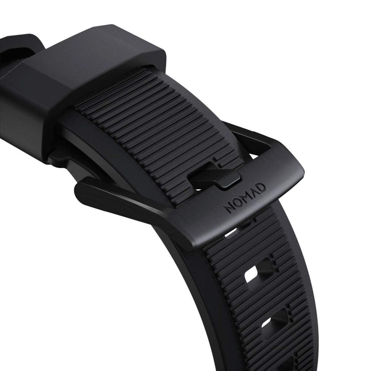 Nahaufnahme einer schwarzen Uhrenarmbandschnalle mit dem Wort NOMAD. Das Armband ist strukturiert.