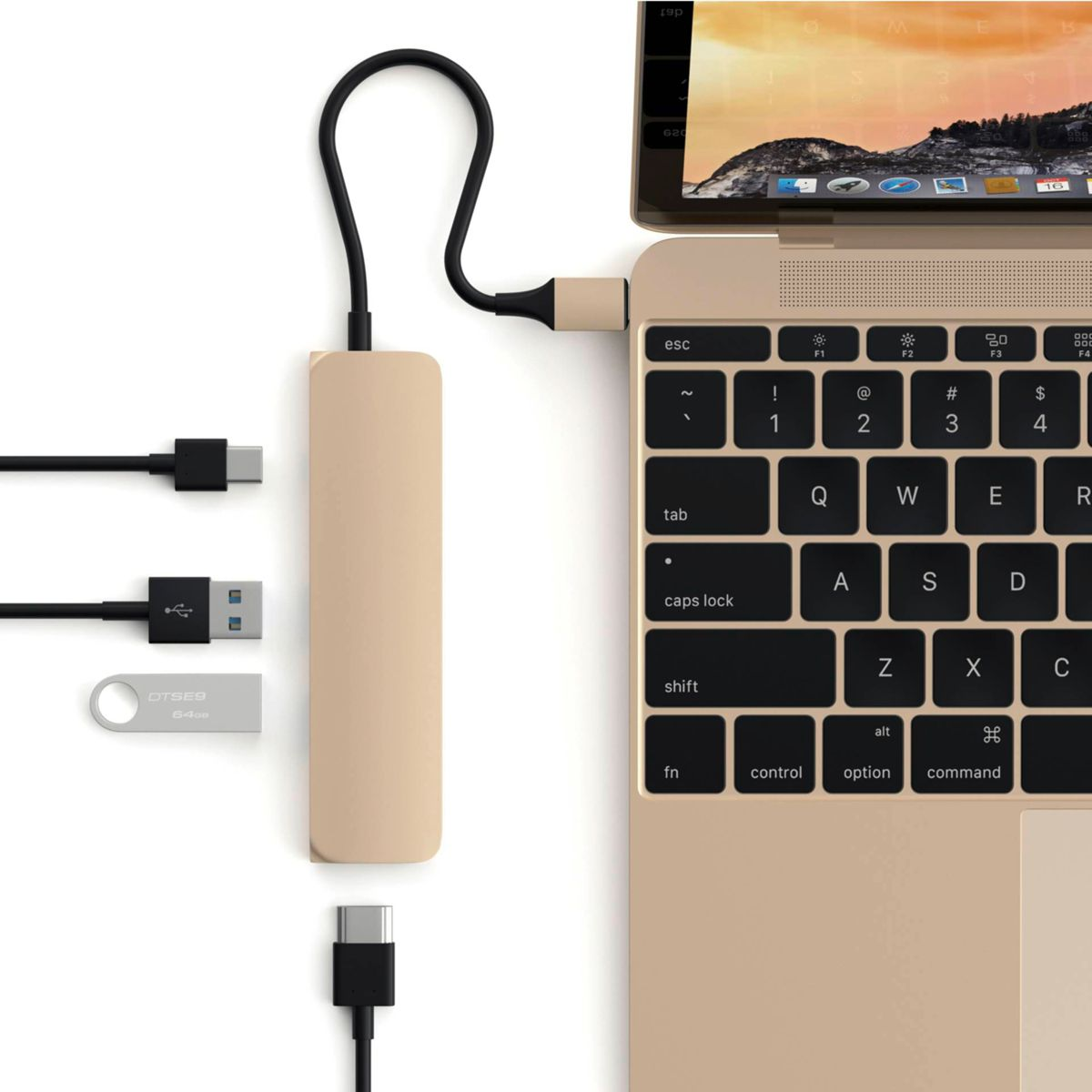Un hub USB-C dorato collegato a un laptop, con varie porte USB, su sfondo bianco.