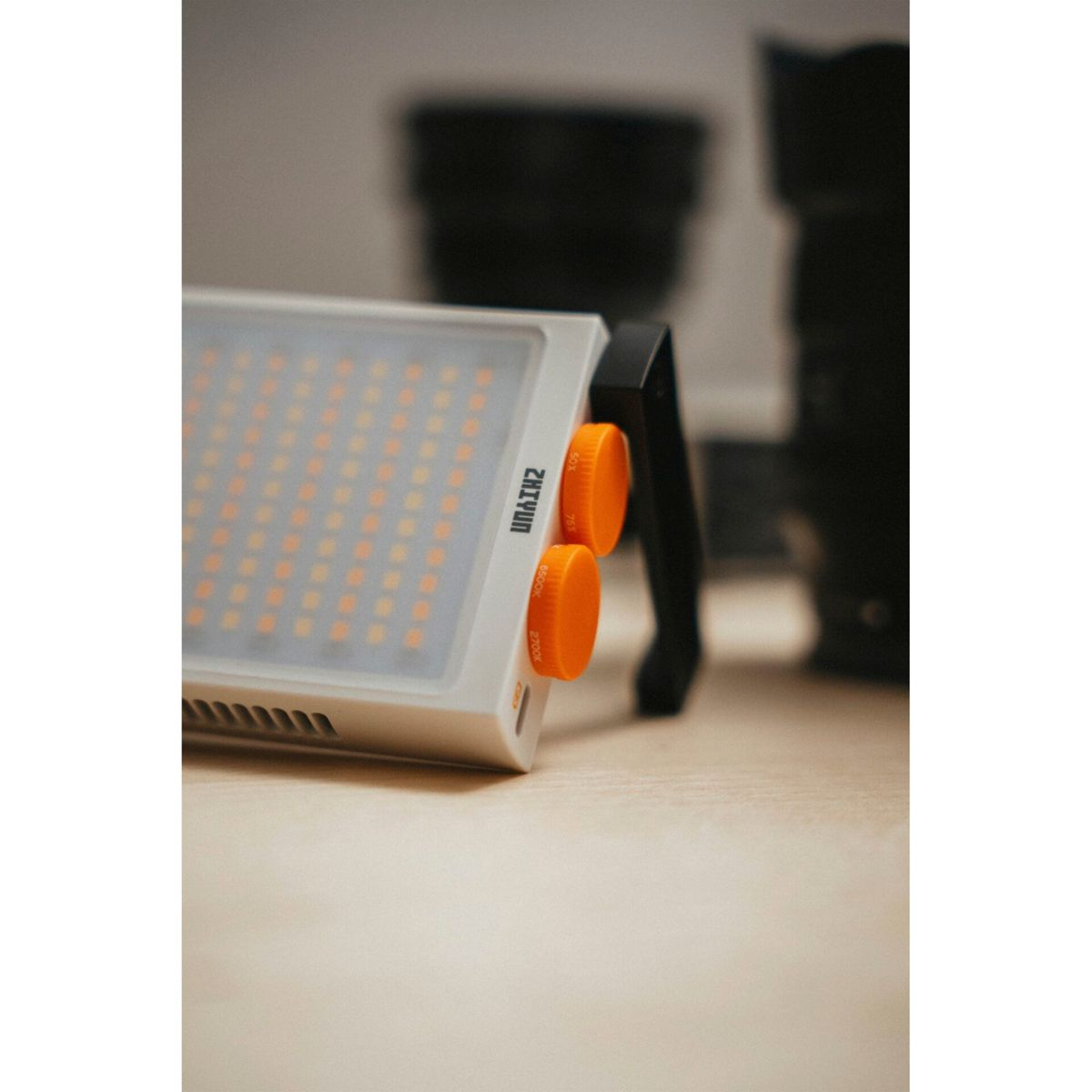 Ein weißes Gerät mit orangefarbenen Knöpfen und einem schwarzen Griff.