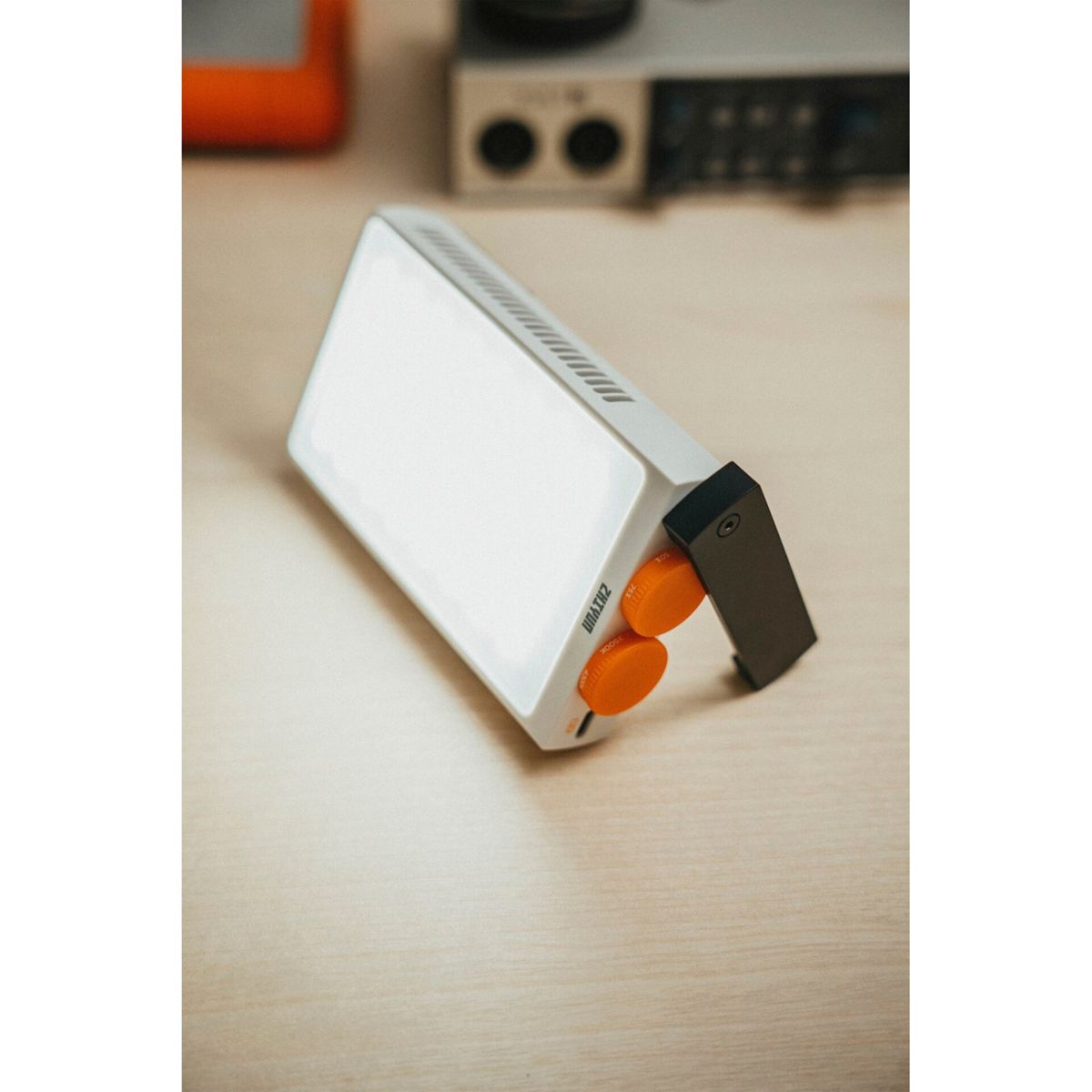 Ein weißes Gerät mit orangefarbenen Knöpfen und einem schwarzen Griff.
