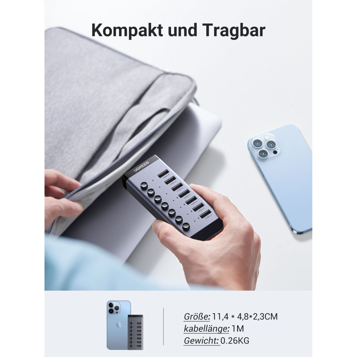 Osoba trzymająca srebrny hub USB. Jasnoszara torba na laptopa w tle.