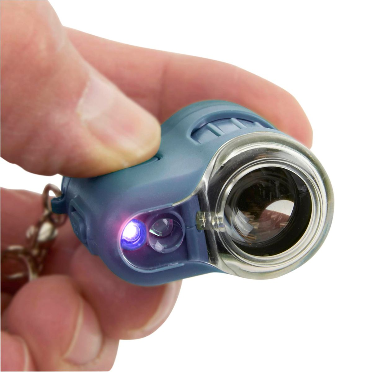 Eine Person hält ein blaues Taschenmikroskop mit Licht an. Weißer Hintergrund.