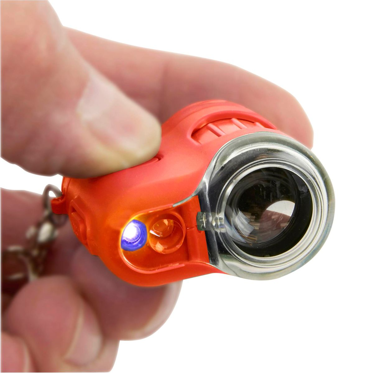 Eine Person hält ein orangefarbenes Taschenmikroskop mit Licht an. Weißer Hintergrund.