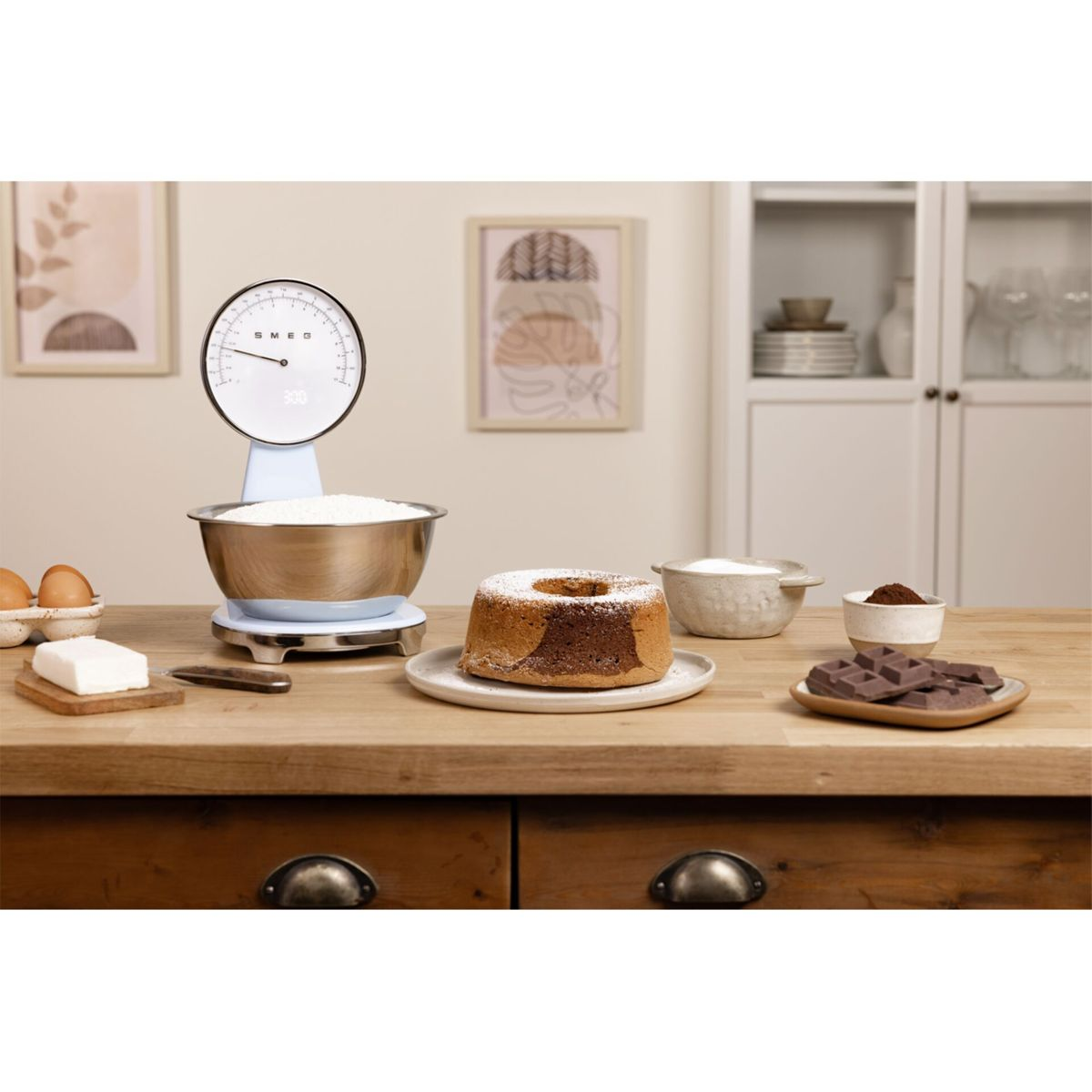 Waga kuchenna z mąką, ciastem i składnikami na drewnianej powierzchni.