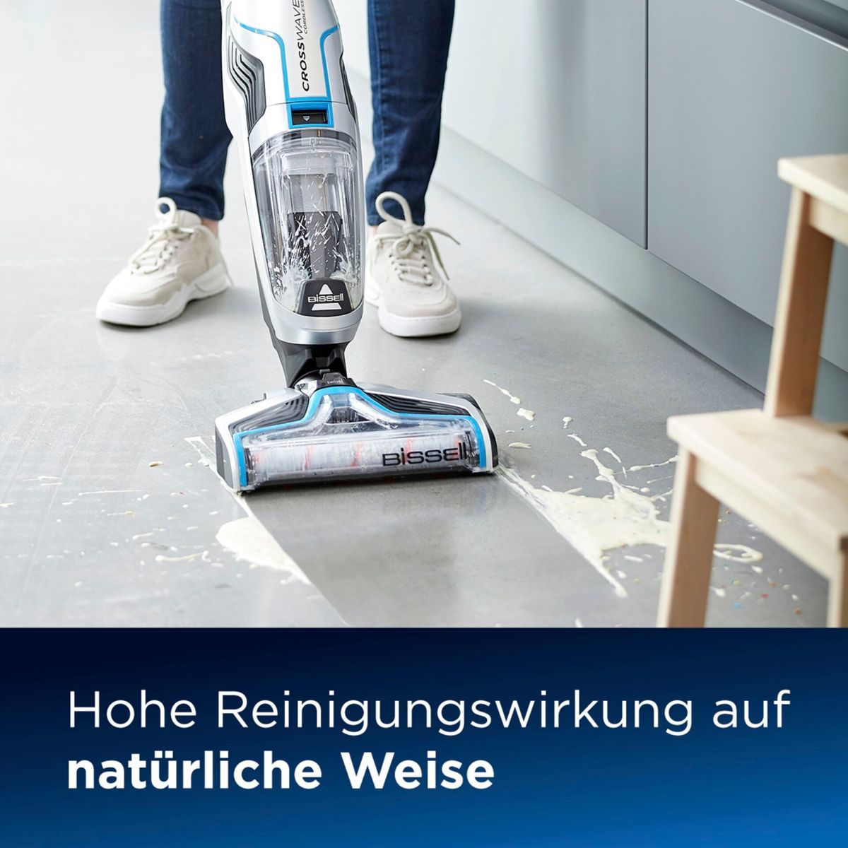 Een persoon gebruikt een stofzuiger op een natte vloer en maakt het schoon.