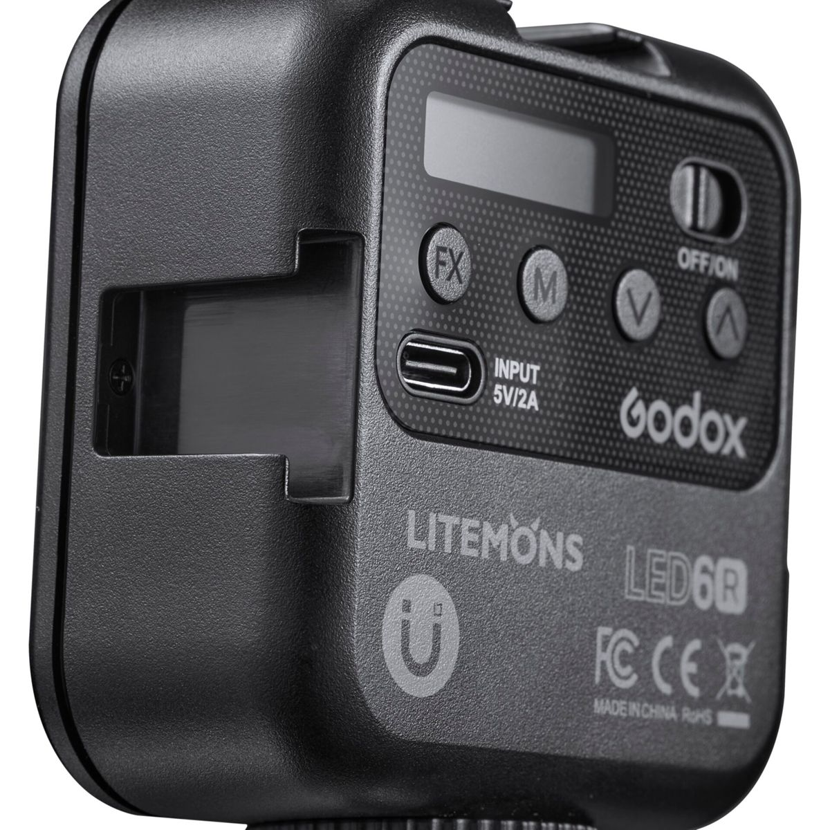 Zbliżenie czarnej lampy LED z przyciskami i wyświetlaczem, widoczne słowo Godox.