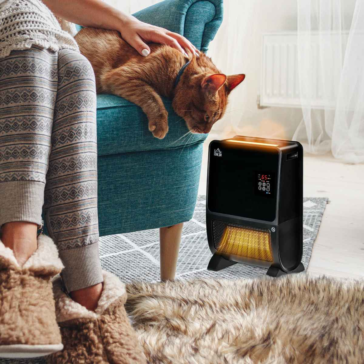 Eine Katze auf einem Sessel, mit einem schwarzen Heizlüfter auf einem Teppich. Beine und Pantoffeln im Vordergrund.