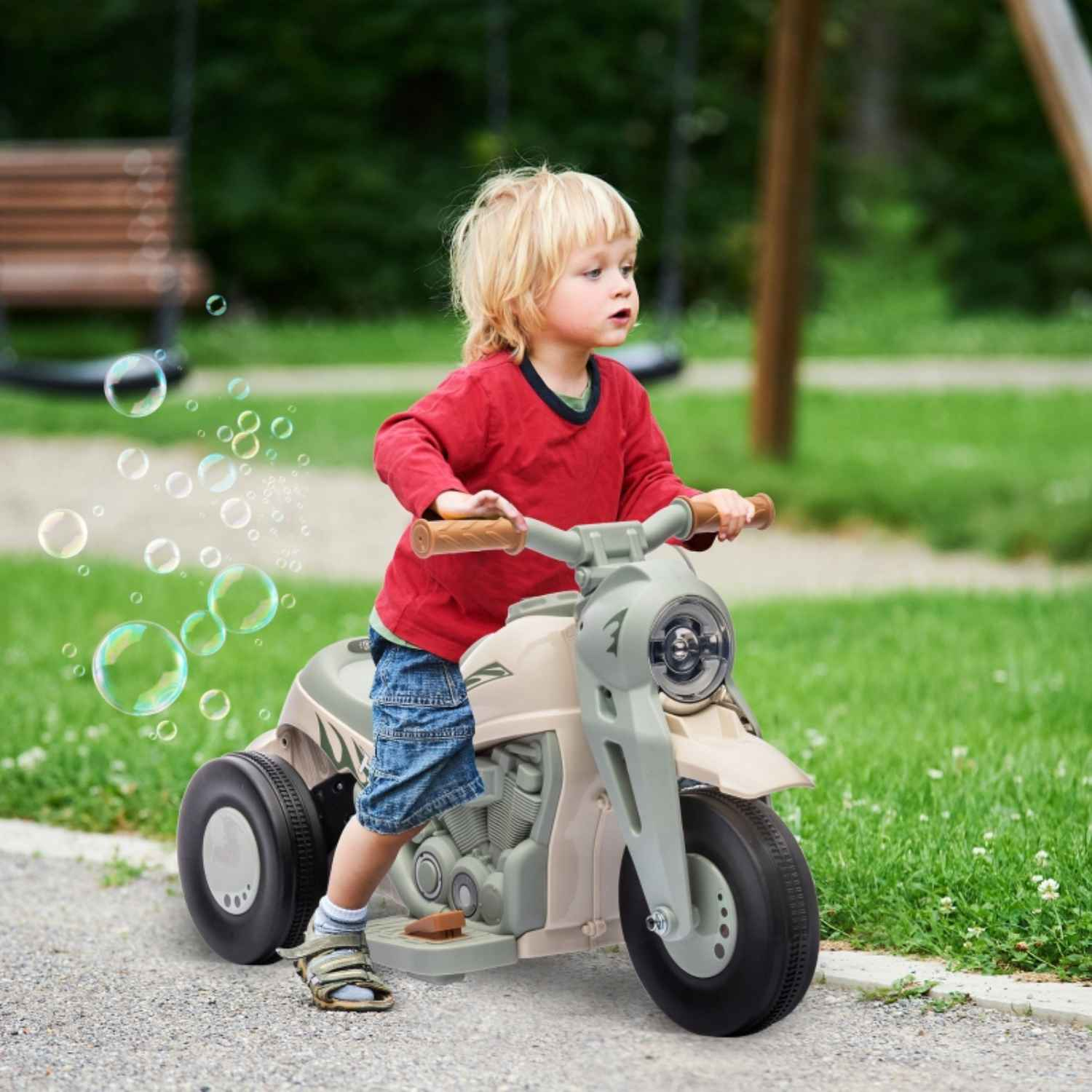 Ein junges Kind fährt mit einem Spielzeugmotorrad. Blasen schweben in der Nähe. Das Kind trägt ein rotes Hemd und blaue Shorts.