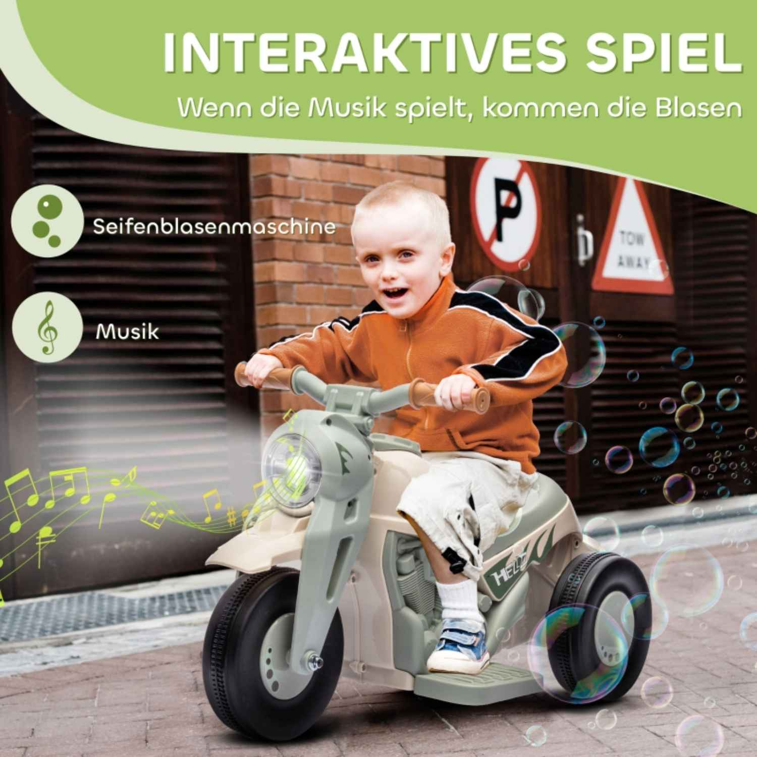 Ein kleiner Junge fährt auf einem weißen und grünen Spielzeugmotorrad mit Blasen.