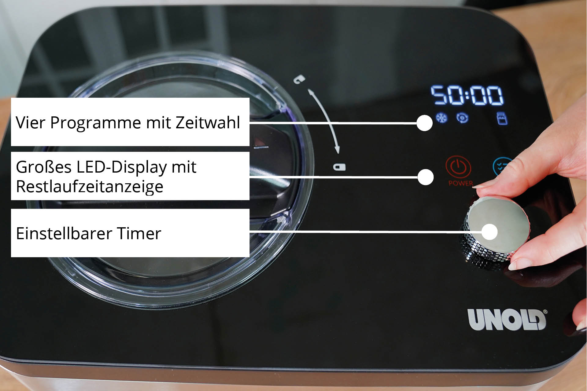 Nahaufnahme einer Eismaschine mit Hand, die den Drehregler betätigt.