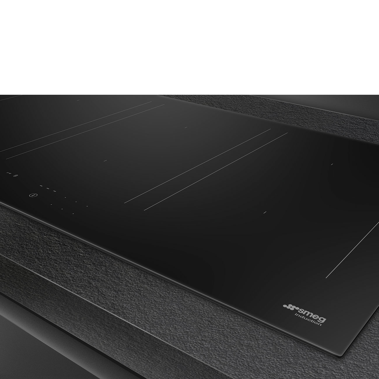 Se muestra una elegante placa de inducción Smeg negra sobre una encimera oscura, con un diseño minimalista.