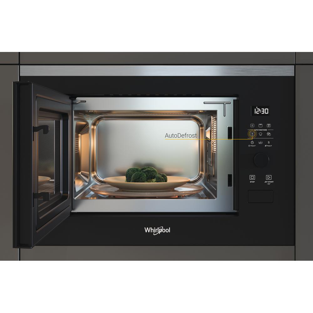 Microondas, puerta abierta, mostrando brócoli en un plato. Se muestra la opción AutoDefrost.