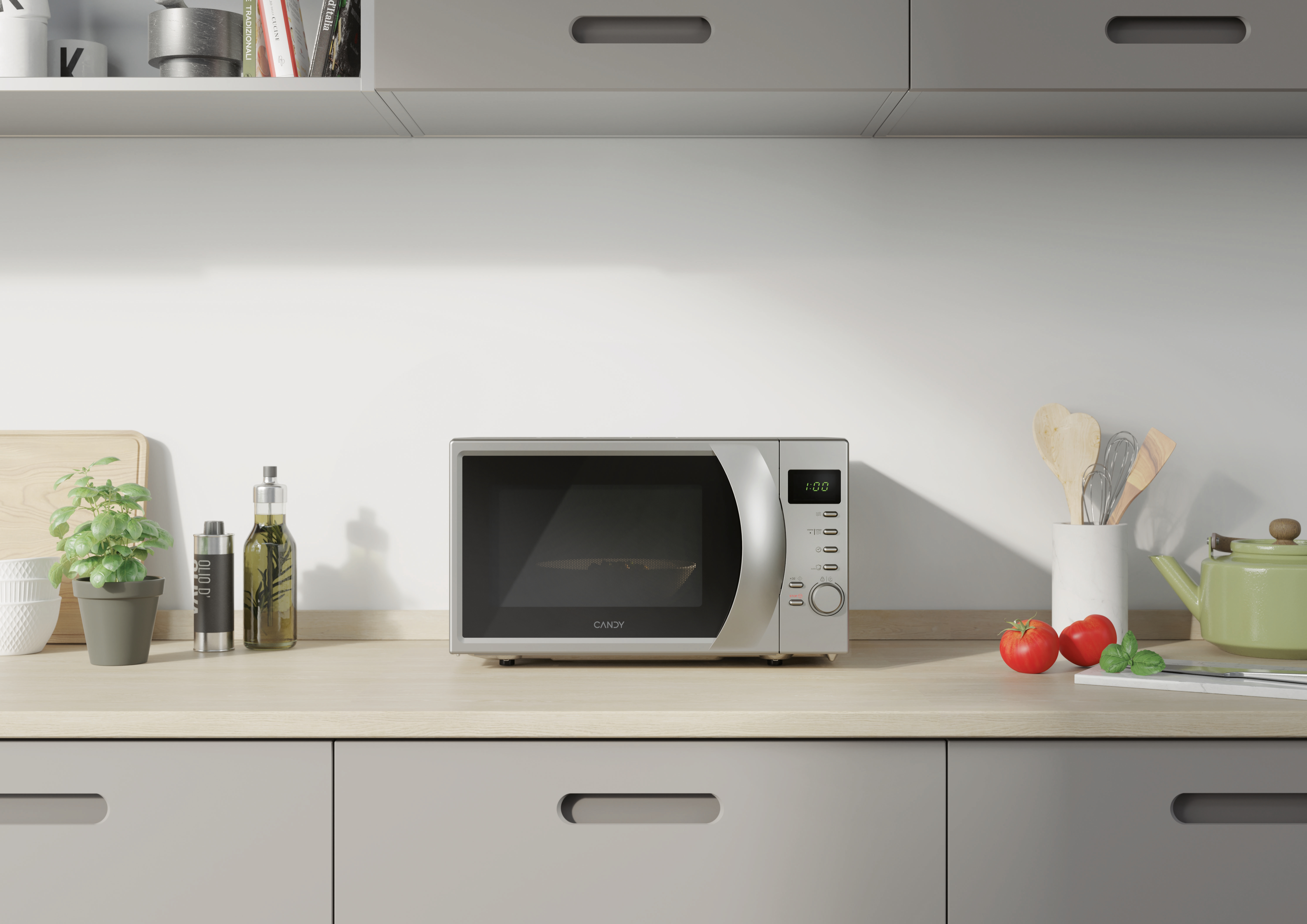 Un forno a microonde su un piano cucina con sfondo bianco, con pomodori e una teiera verde.
