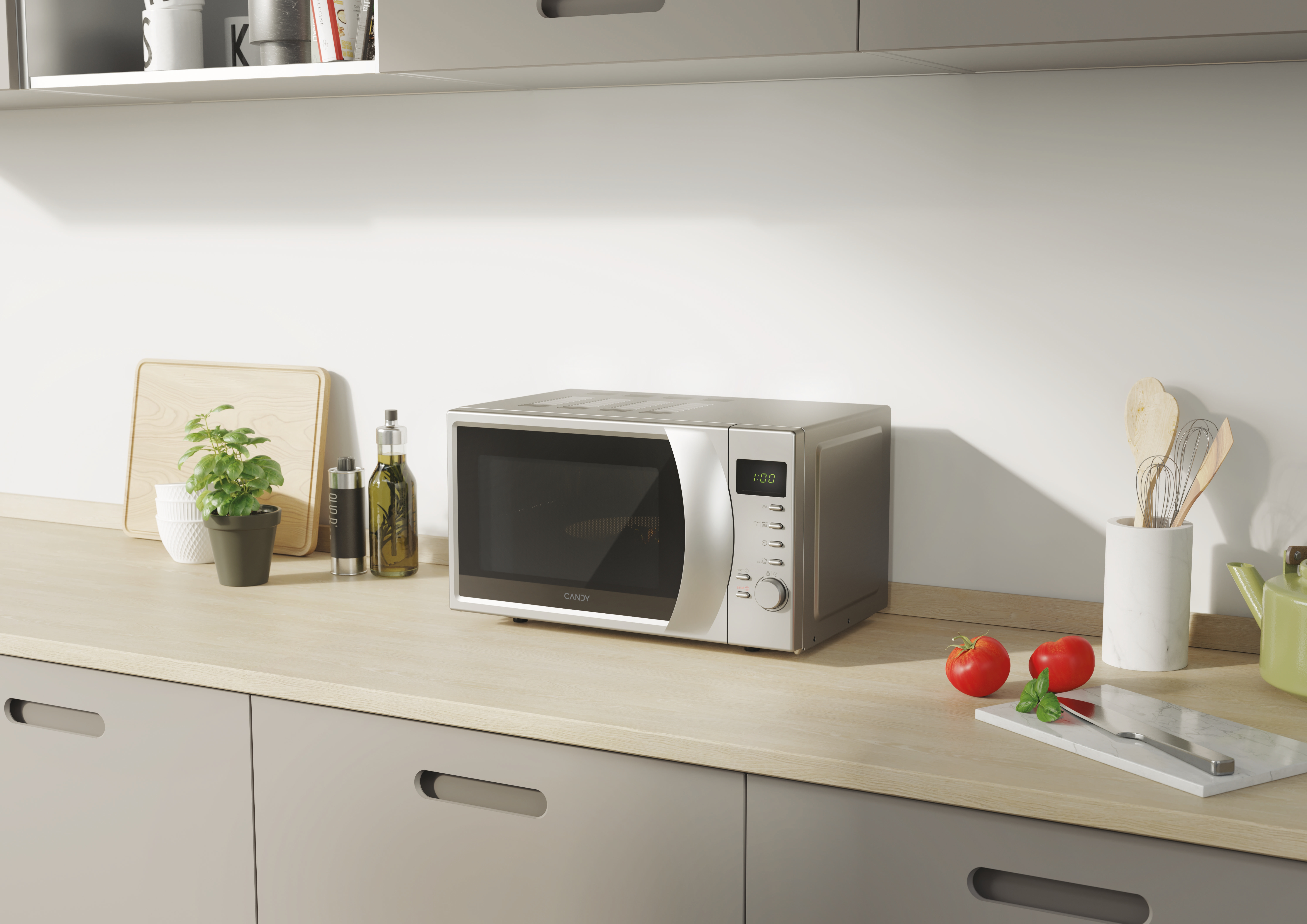 Un forno a microonde in acciaio inossidabile su un piano di lavoro della cucina. Ci sono anche pomodori, basilico e utensili.