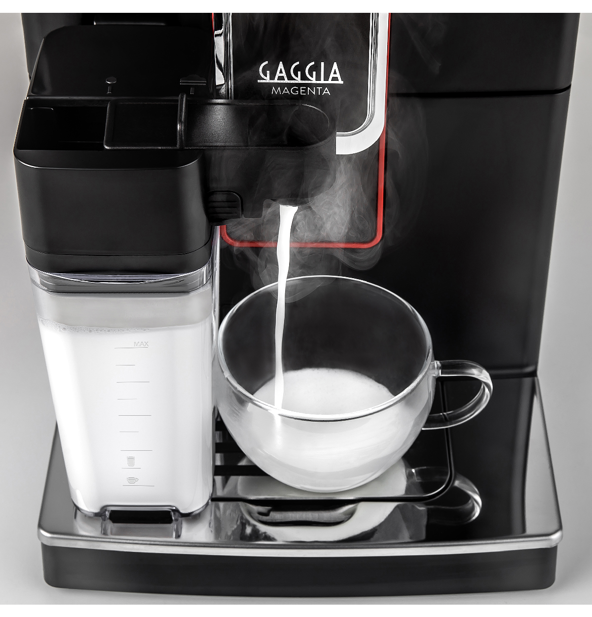 Een Gaggia Magenta machine die melkschuim in een glazen kopje doseert, met stoom zichtbaar.