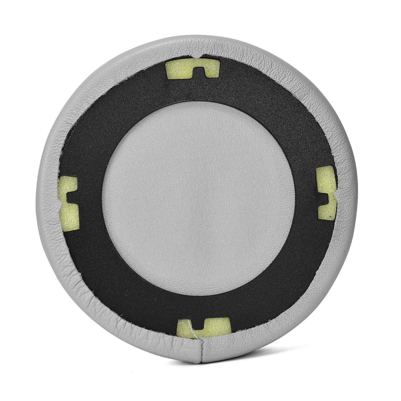 Zbliżenie jasnoszarej poduszki nausznej z czarnym wewnętrznym pierścieniem i żółtymi piankowymi wkładkami, na białej powierzchni.