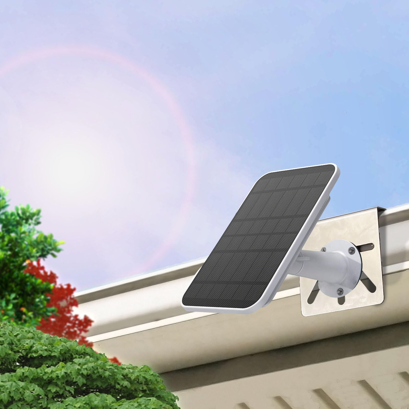 Ein weißes Solarpanel, montiert an einer Dachrinne. Blauer Himmel und grünes Laub im Hintergrund.