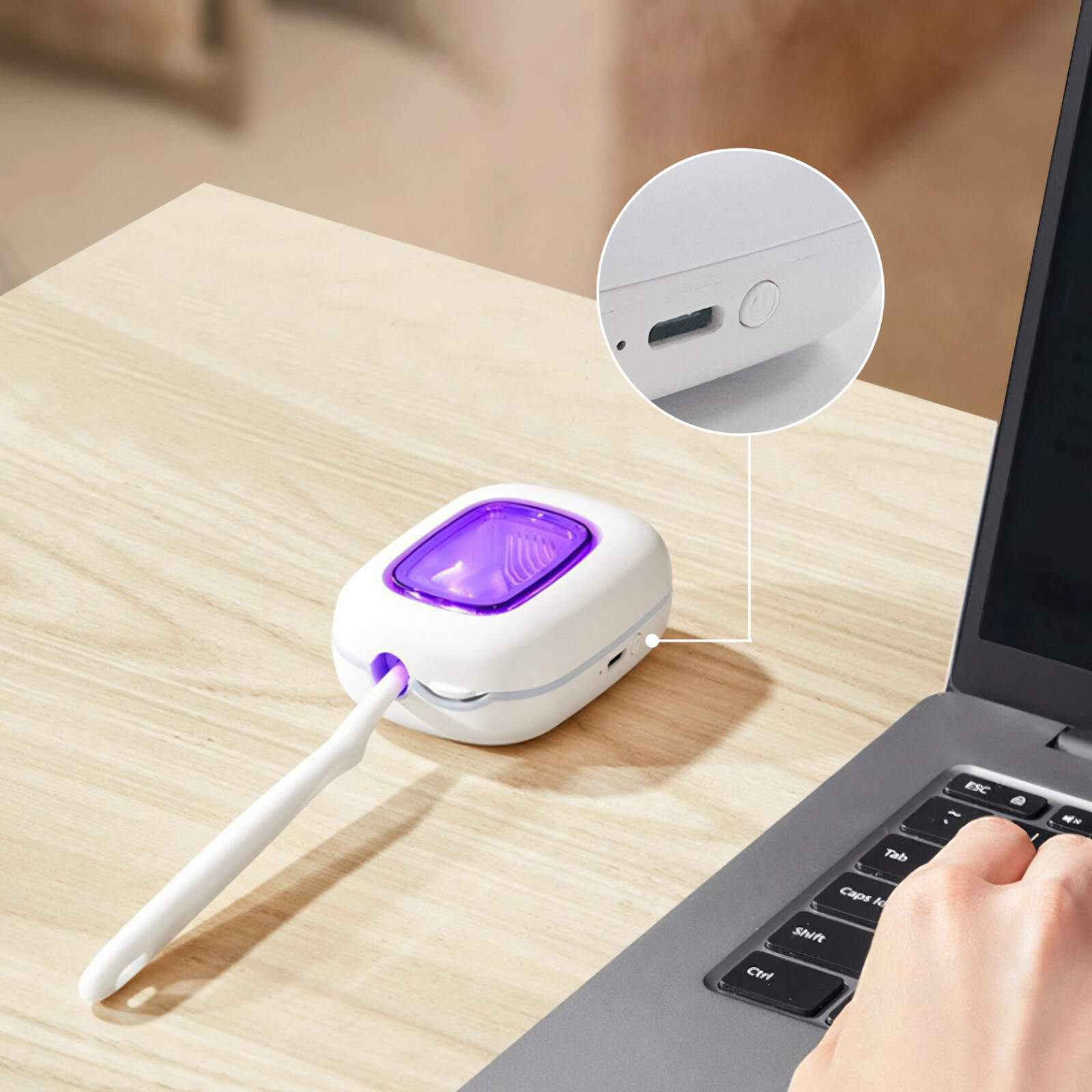 Ein kleines, weißes Gerät mit lila Licht, eine Zahnbürste und ein Laptop, was auf Mundhygiene und Technik hindeutet.