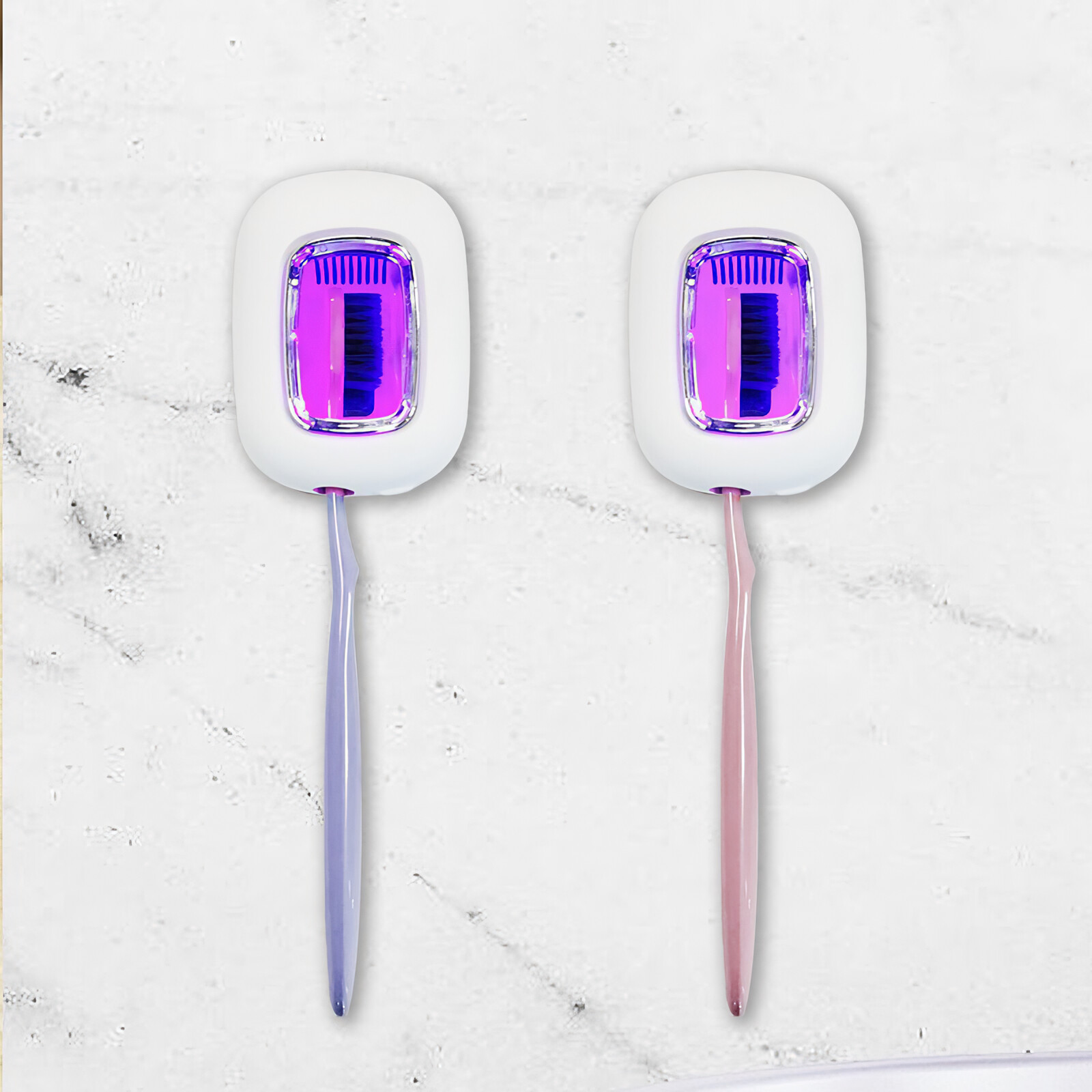 Zwei Zahnbürsten-Desinfektionsgeräte mit lila und rosa Griffen auf Marmoroberfläche.