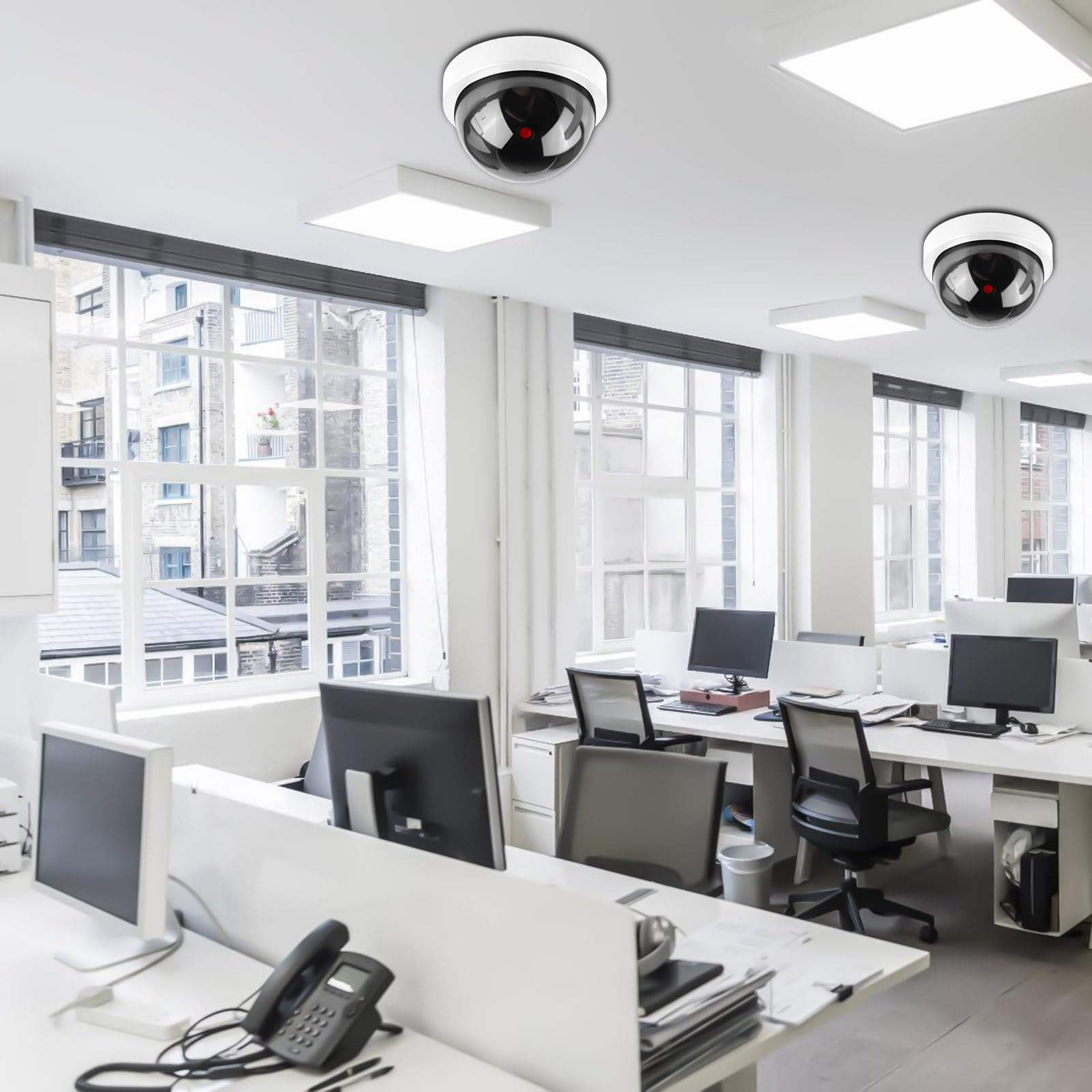Ein Büro mit mehreren Schreibtischen, Computern und drei an der Decke montierten Überwachungskameras.