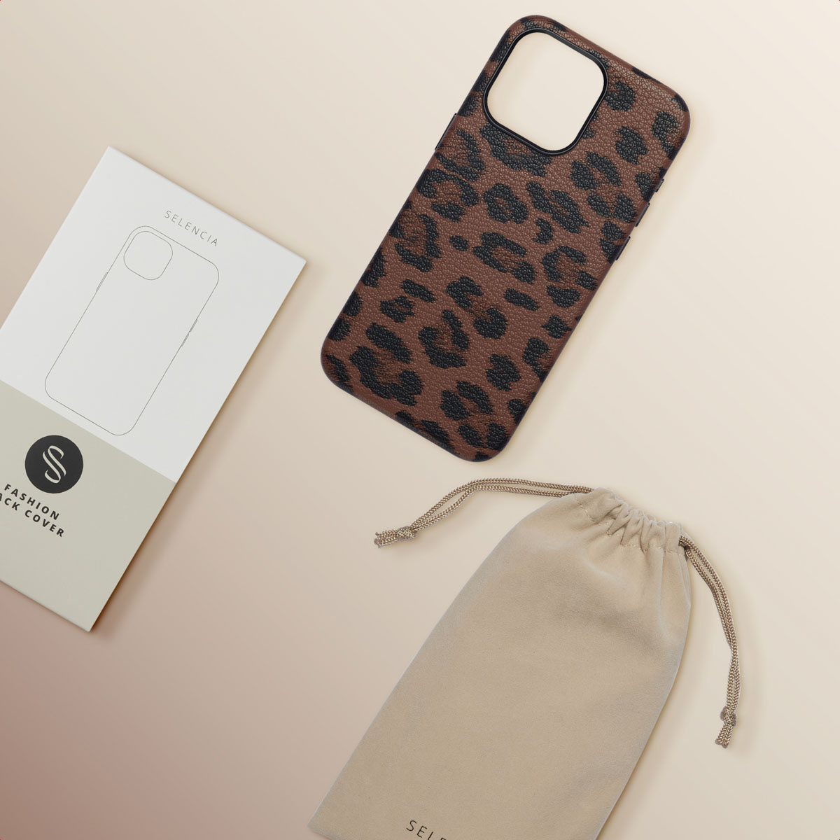 Une coque de téléphone ouverte avec un motif léopard, un sac beige et une boîte blanche.