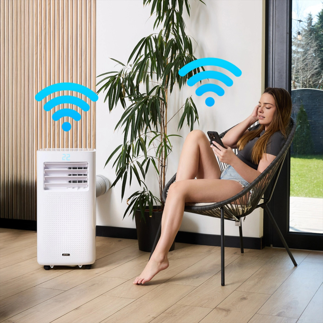 Kobieta korzystająca z telefonu w pobliżu białego klimatyzatora z symbolami wifi.