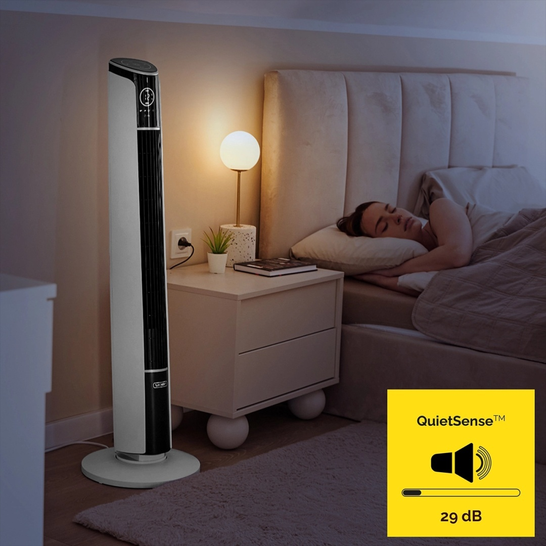Sypialnia ze śpiącą kobietą, wentylatorem stojącym, szafką nocną i żółtym logo QuietSense.