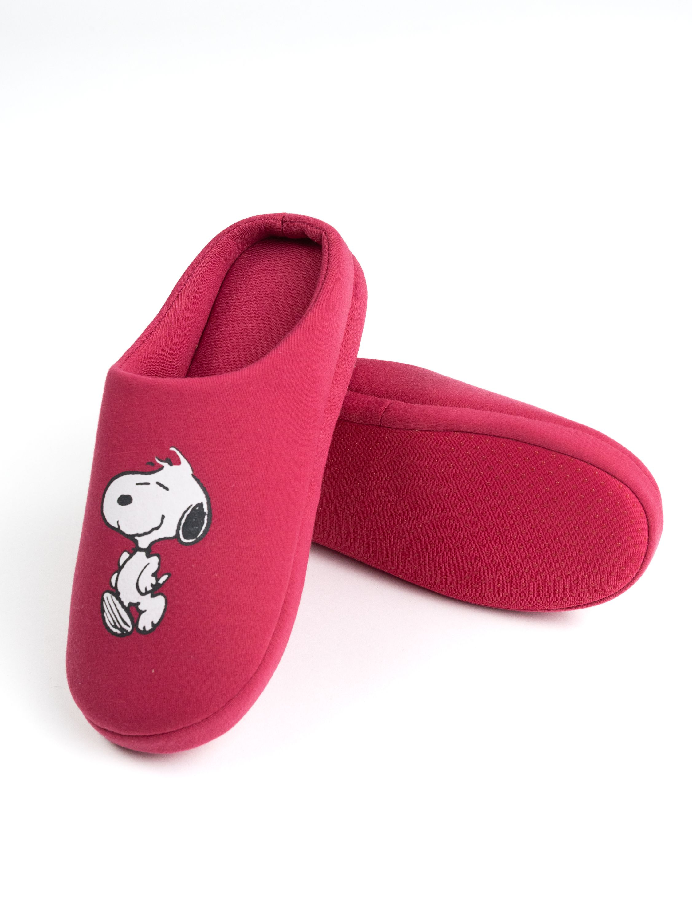 Rote Snoopy-Hausschuhe. Snoopy ist oben auf den Hausschuhen. Weißer Hintergrund.