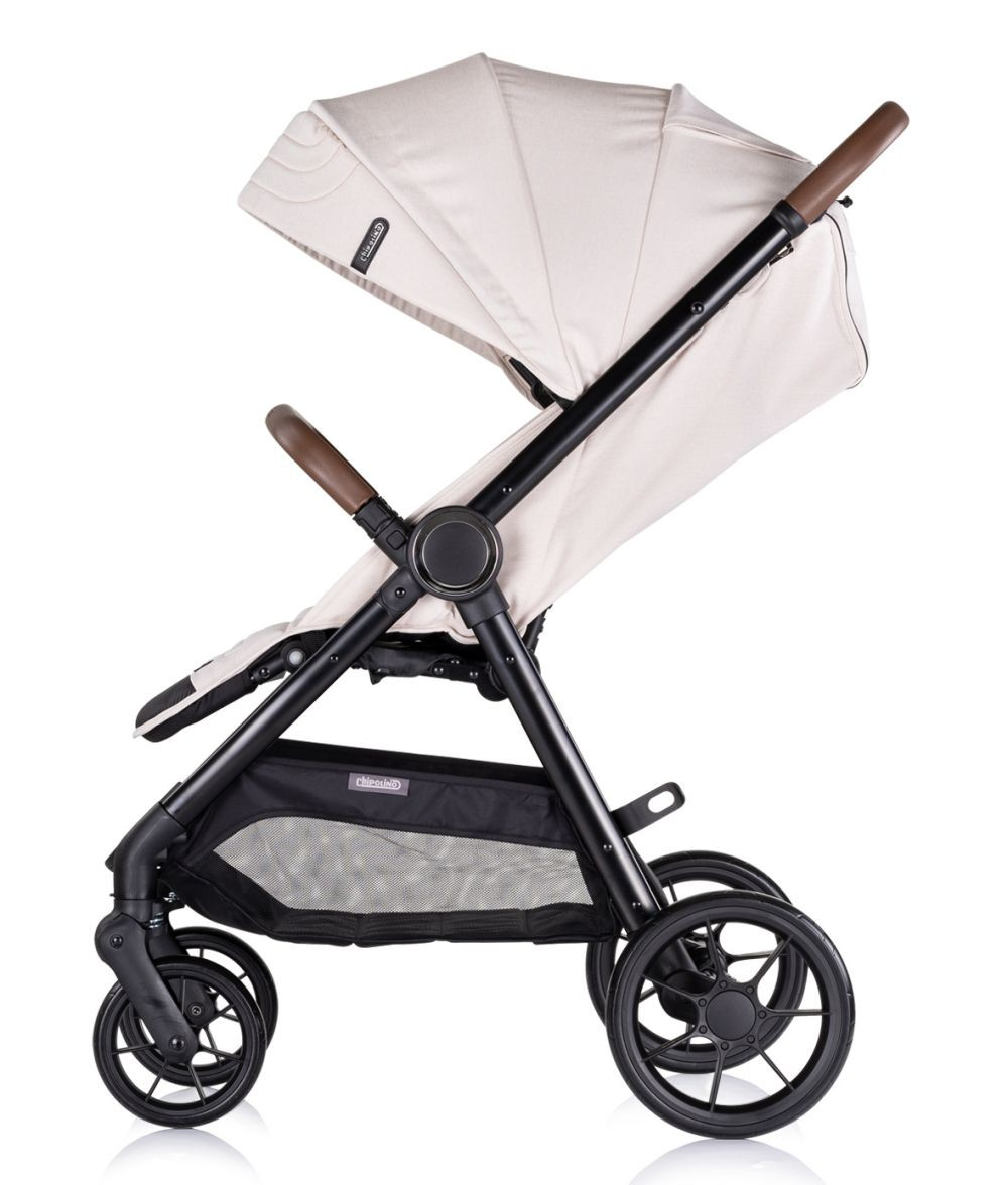 Ein beiger Kinderwagen mit schwarzem Rahmen, mit einem Sonnendach und einem Aufbewahrungskorb darunter.
