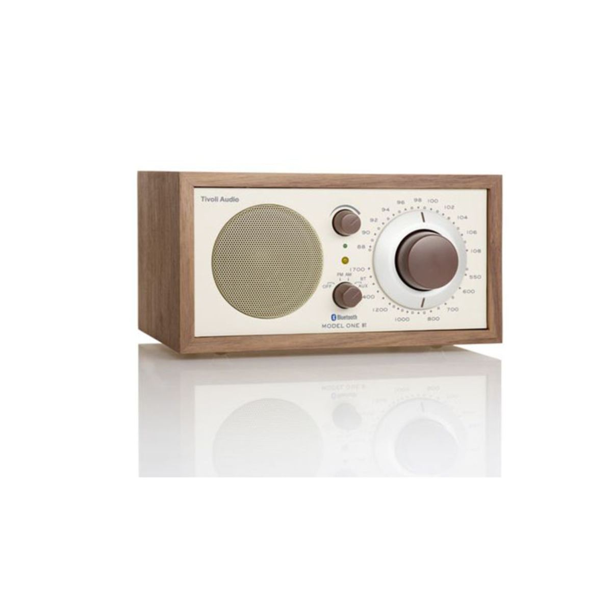 Ein Retro-Radio aus Holz mit cremefarbener Vorderseite. Es hat einen Lautsprecher, zwei Knöpfe und ein Zifferblatt. Der Text 'Tivoli Audio' steht oben.