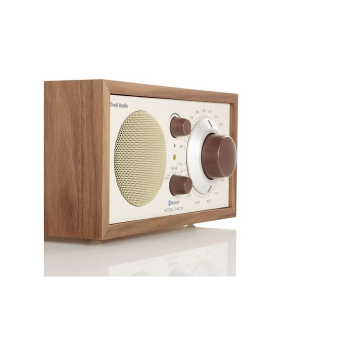 Ein Holzradio mit cremefarbenem Gesicht und braunen Knöpfen. Es befindet sich auf weißem Hintergrund.