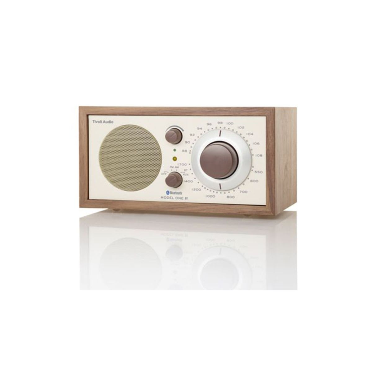 Ein Retro-Radio aus Holz mit cremefarbener Vorderseite. Es hat einen Lautsprecher, zwei Knöpfe und ein Zifferblatt. Der Text 'Tivoli Audio' steht oben.