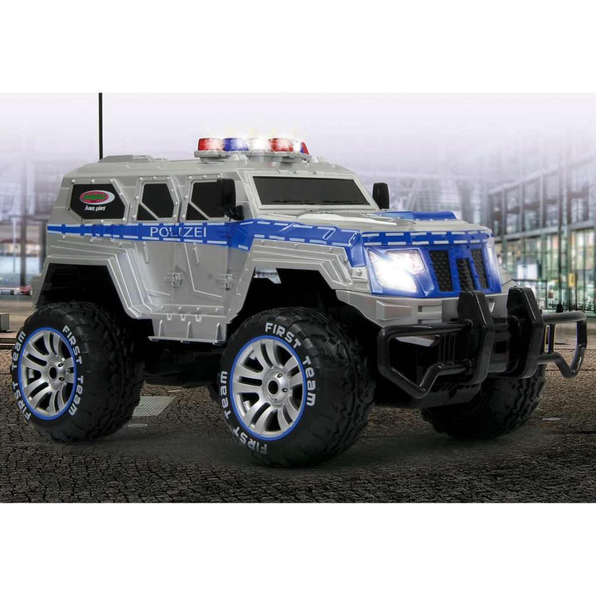 Ein silberner und blauer Spielzeug-Polizeitruck mit großen schwarzen Reifen, Lichtern oben und dem Wort POLIZEI.