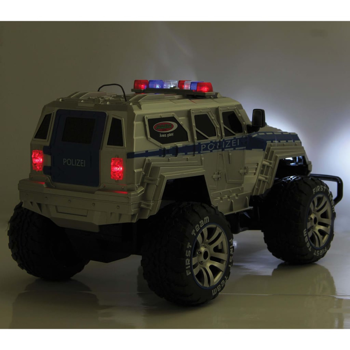 Ein silberner Polizeiwagen mit eingeschalteten Lichtern, von hinten gesehen, mit großen Reifen und dem Wort 'POLIZEI' an der Seite.
