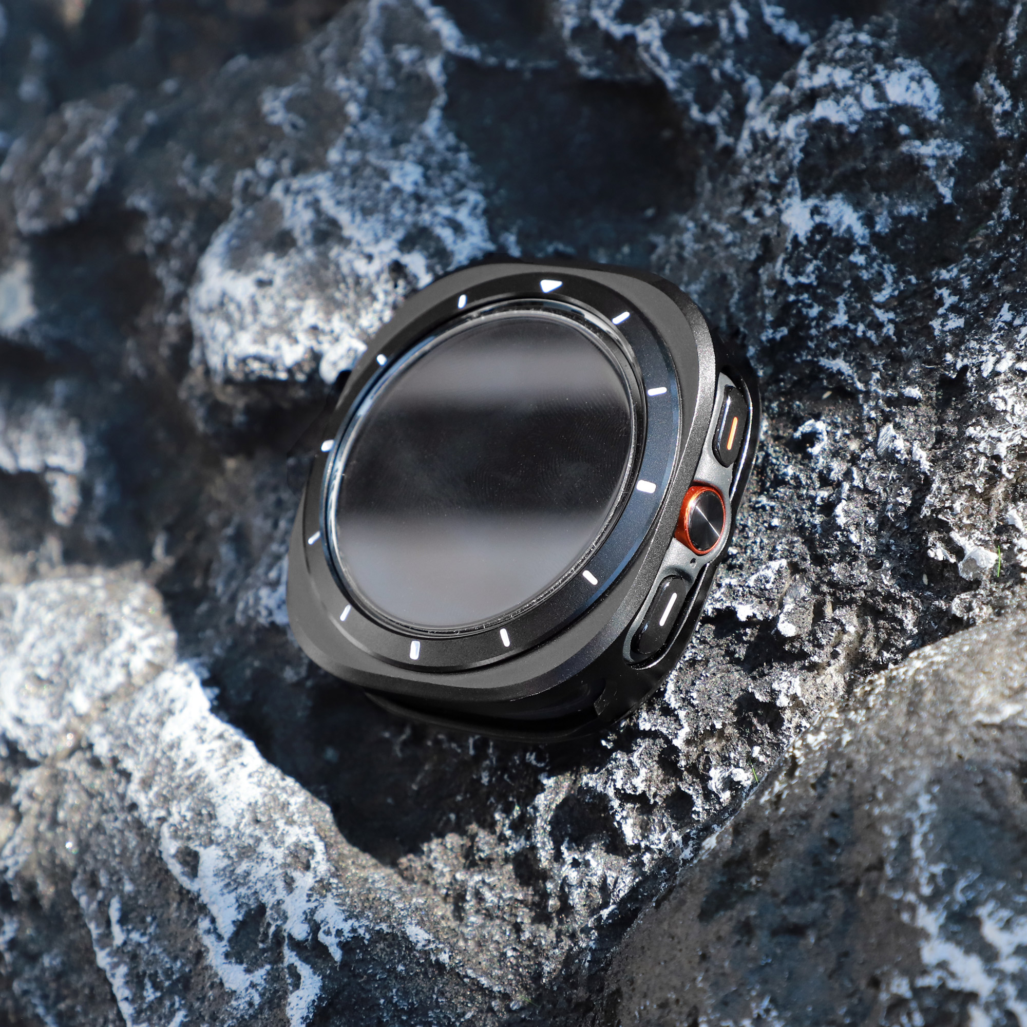 Eine schwarze Smartwatch auf einer Felsenoberfläche. Die Uhr hat einen runden Bildschirm und eine schwarze Lünette.