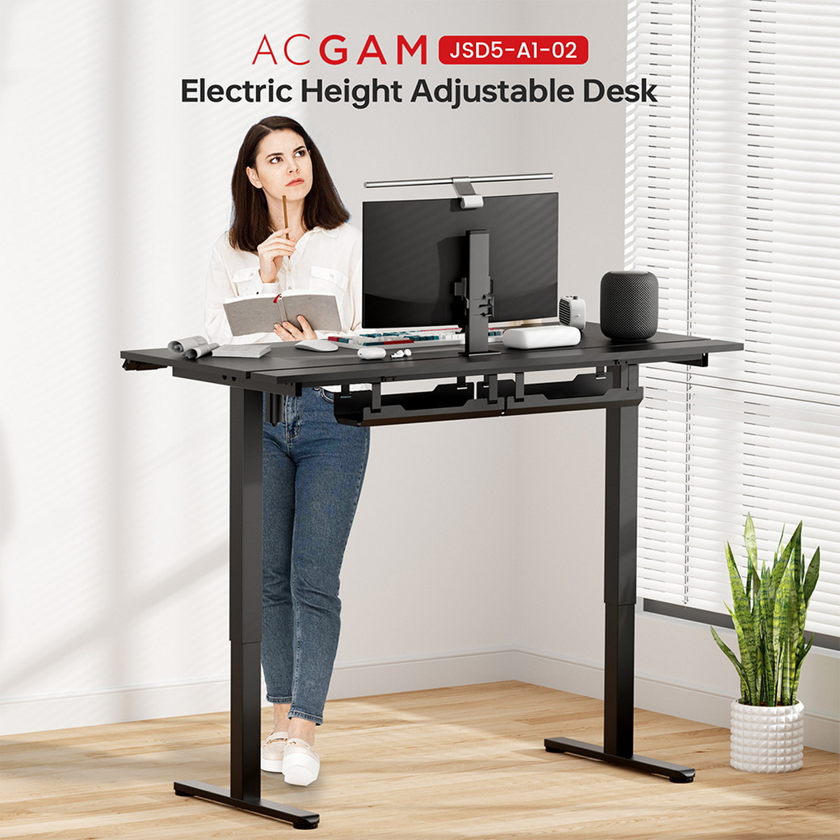 Eine Frau steht an einem schwarzen Schreibtisch. Text: ACGAM Elektrisch höhenverstellbarer Schreibtisch. Ein Computermonitor ist sichtbar.