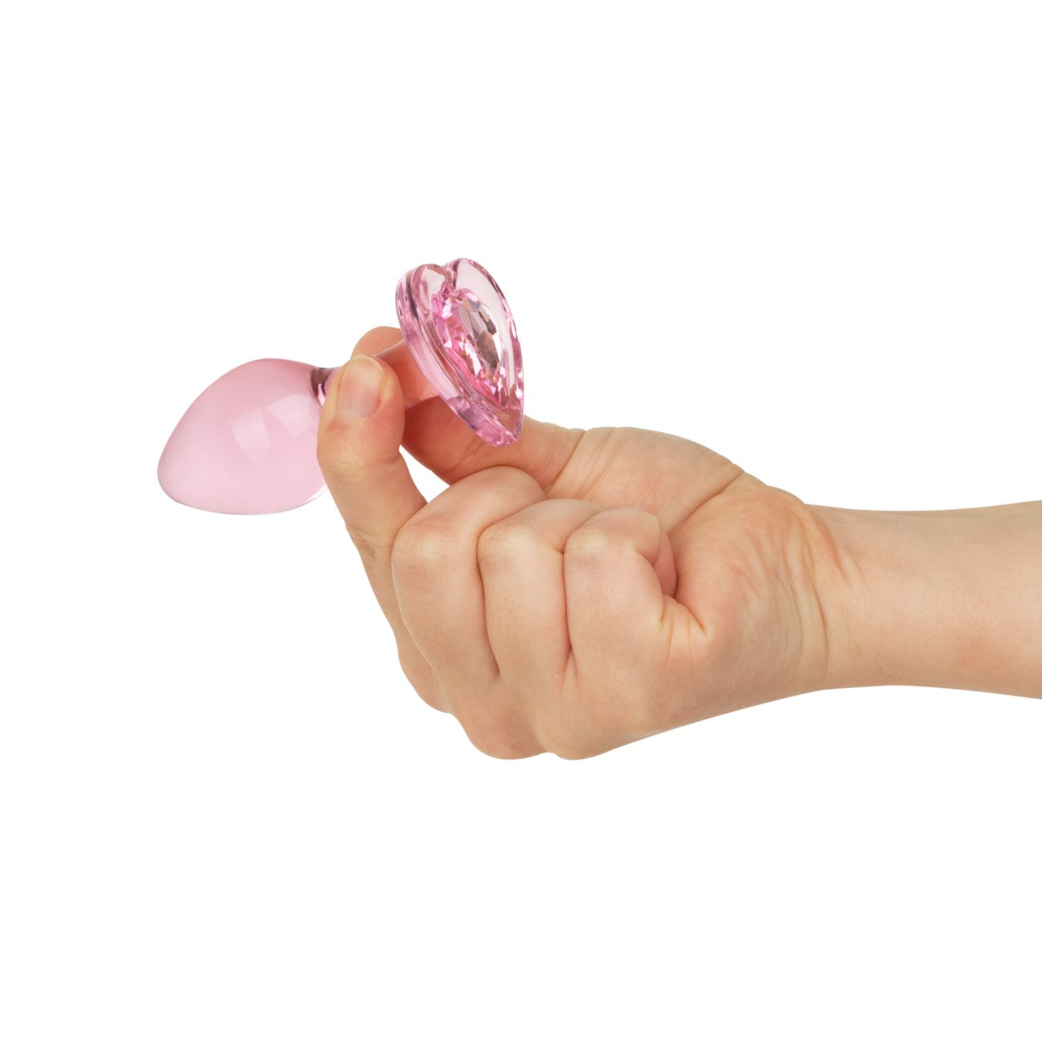 Hand hält einen rosa, herzförmigen Analknopf, Nahaufnahme.