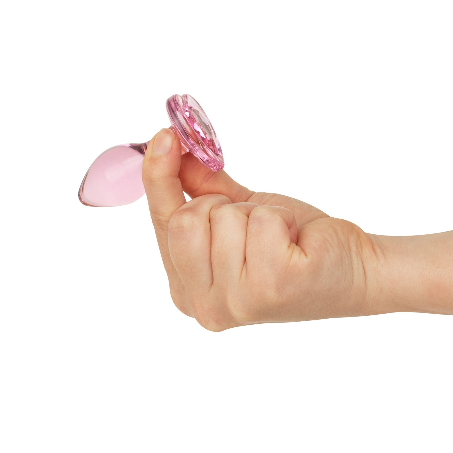 Eine Hand hält einen rosa Glas-Buttplug vor weißem Hintergrund. Der Plug hat einen ausgestellten Boden und eine abgerundete Oberseite.