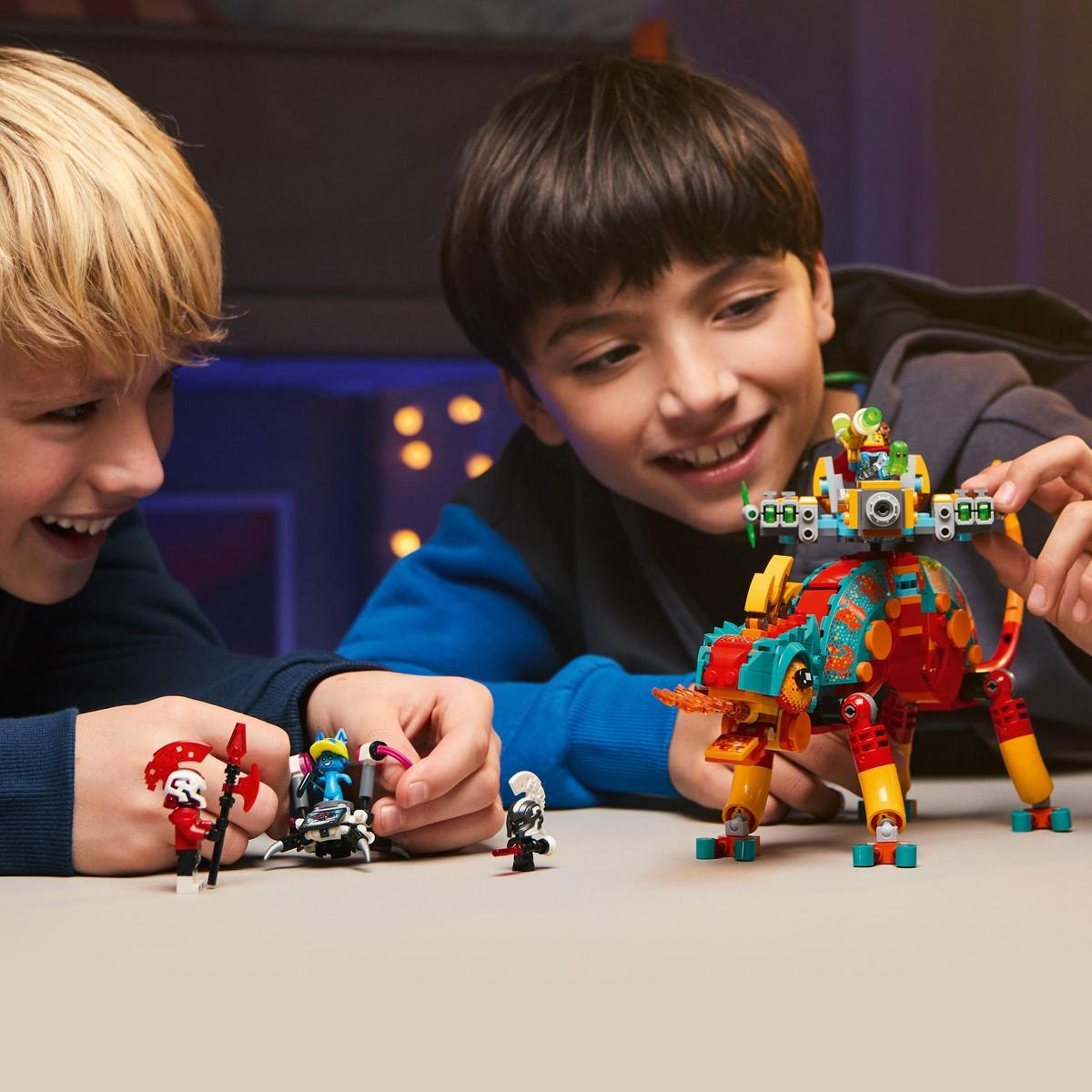 Dwóch chłopców bawiących się zabawką dinozaura LEGO z figurkami.