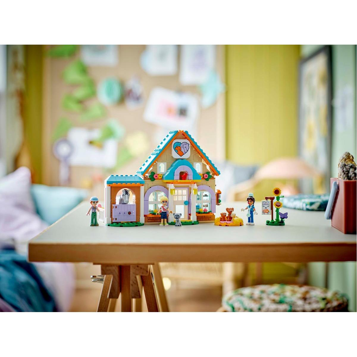 Un ensemble Lego Friends avec une maison, des mini-figurines et des accessoires sur une table.