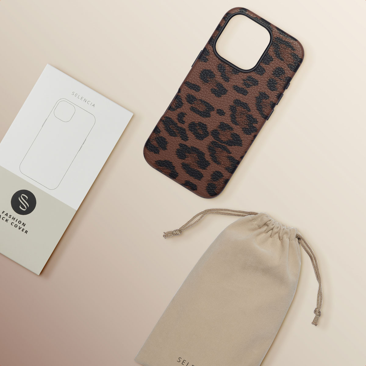 Una custodia per telefono, una borsa e un imballaggio su una superficie beige. La custodia ha una stampa leopardata.