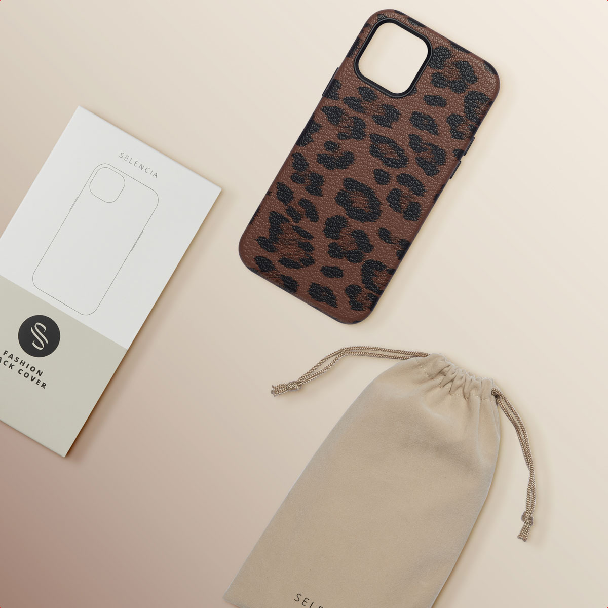 Bruin telefoonhoesje met luipaardprint, een doos en een beige zakje op een lichtbruin oppervlak.