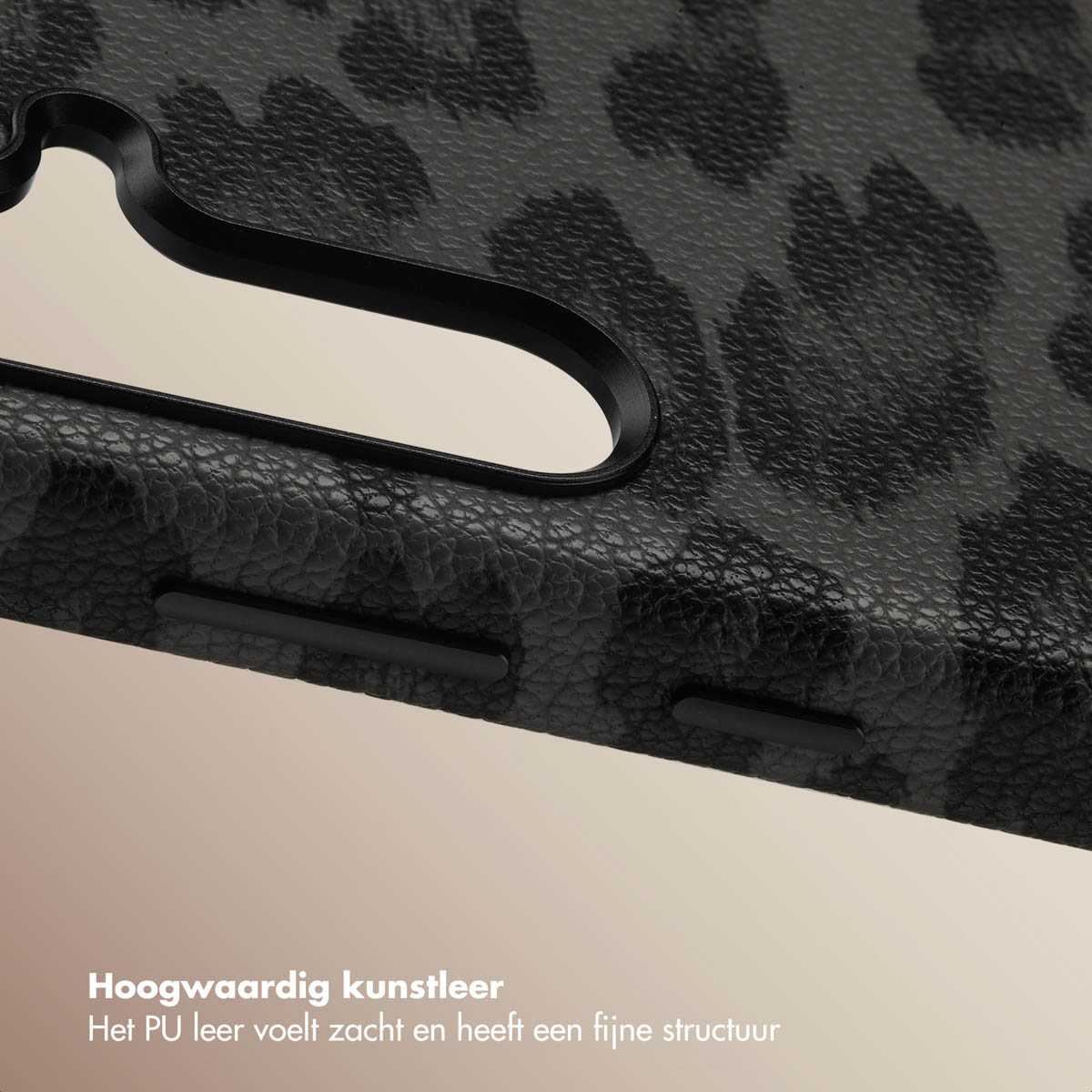 Close-up van een zwarte telefoonhoes met luipaardprint met knoppen en textuur.