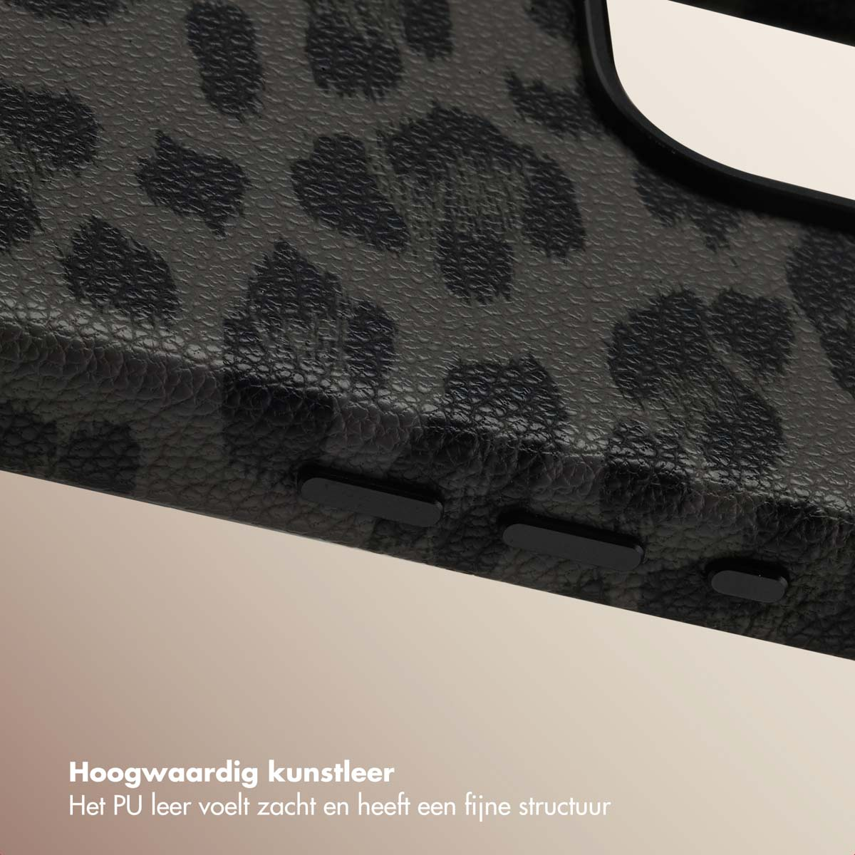 Close-up van een zwarte telefoonhoes met luipaardprint en knoppen. De achtergrond is lichtbeige.