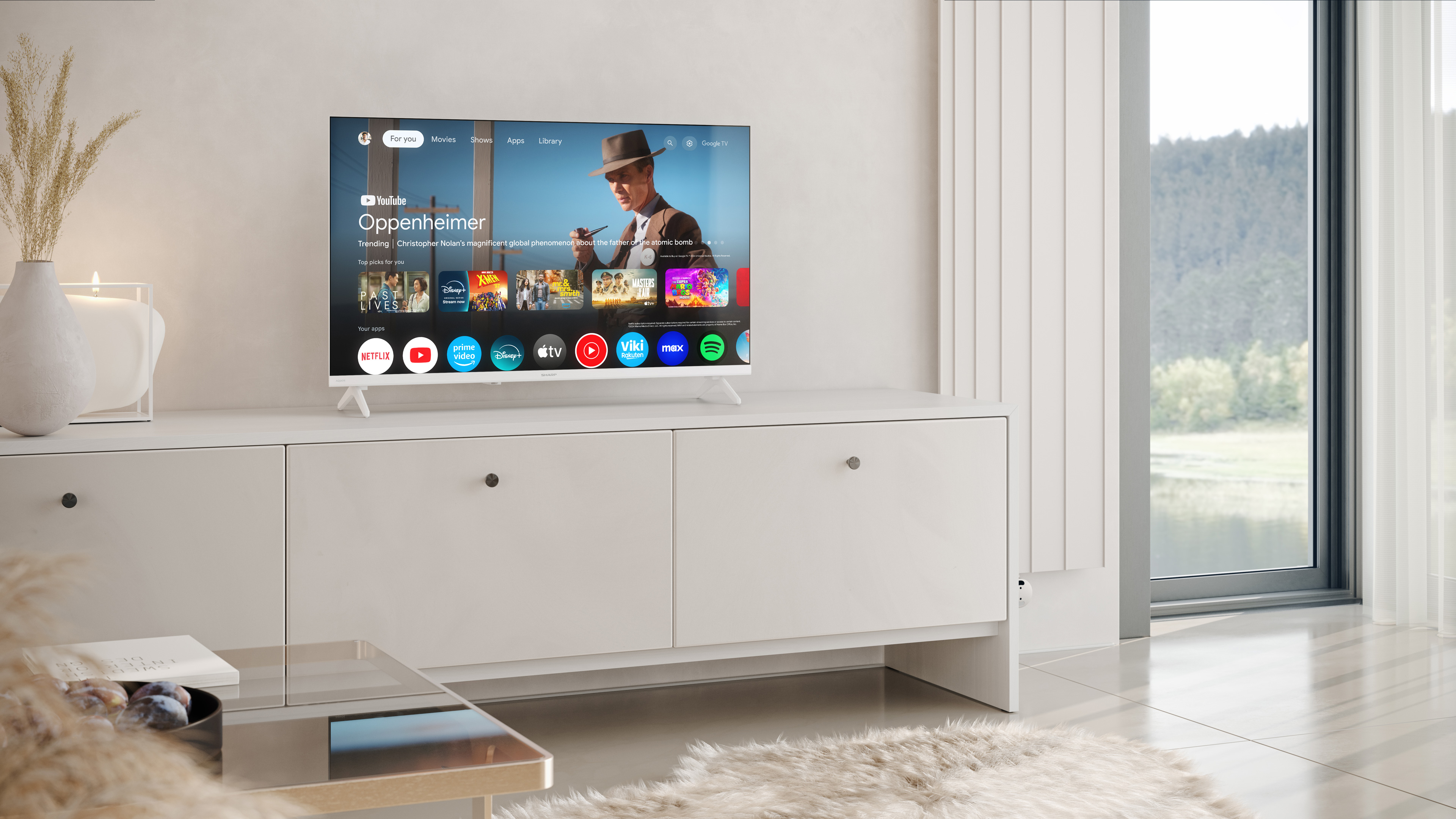 Ein Fernseher steht auf einem weißen Schrank. Der Bildschirm zeigt einen Film, der Hintergrund ist ein Raum.