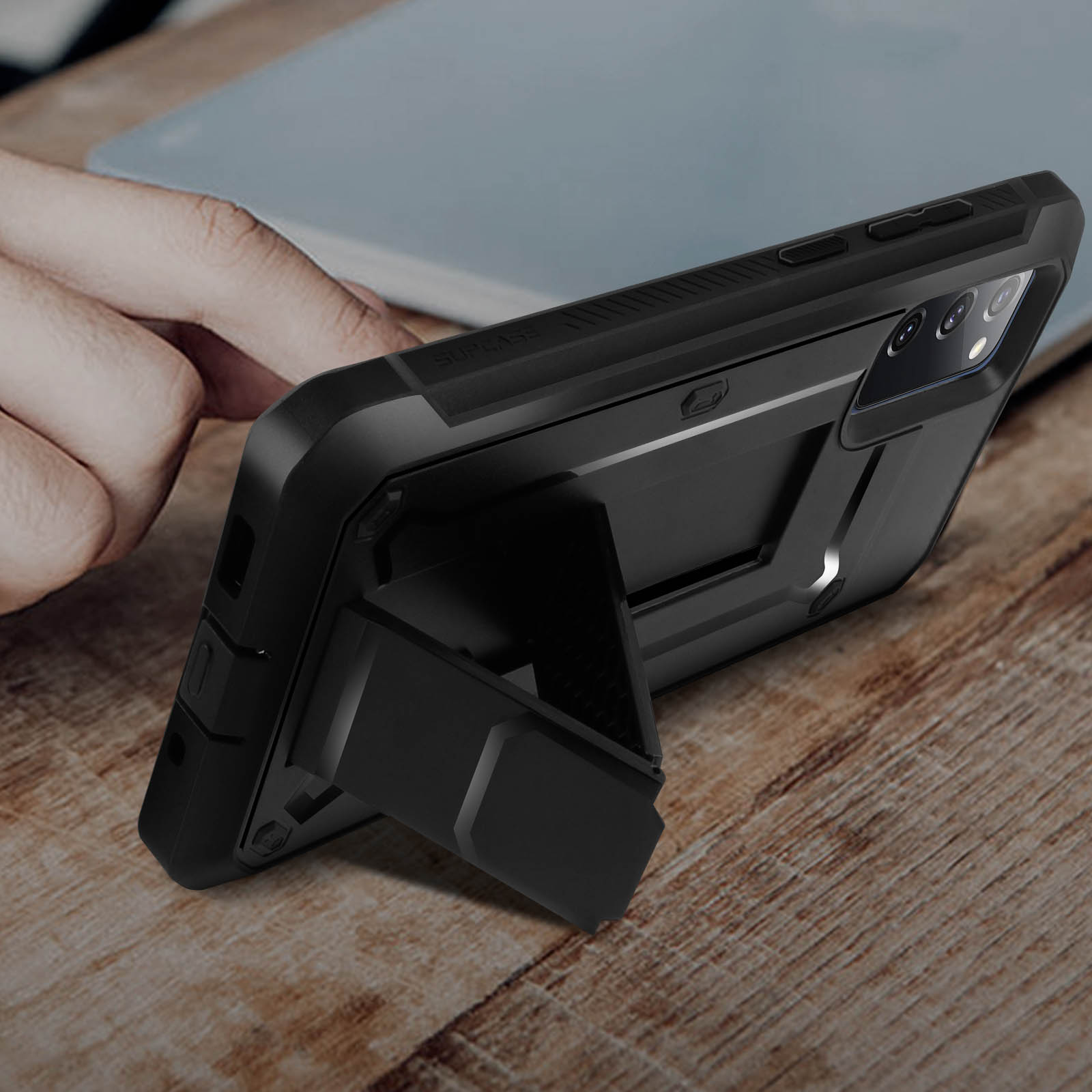 Una custodia per telefono con cavalletto è appoggiata su un tavolo di legno.