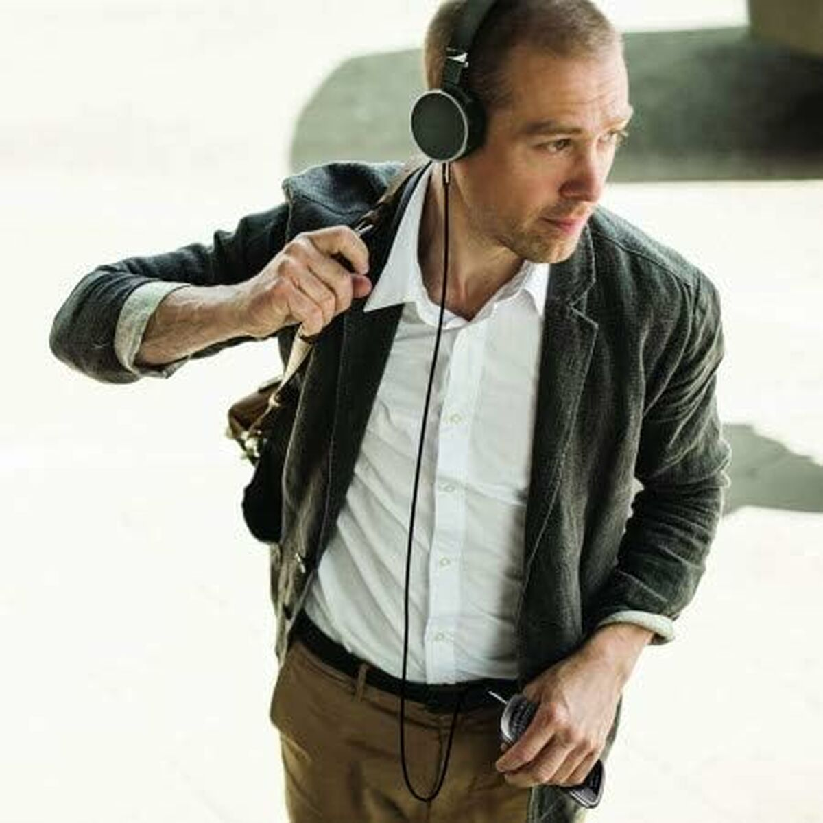 Homme portant un casque et tenant un téléphone et un câble.