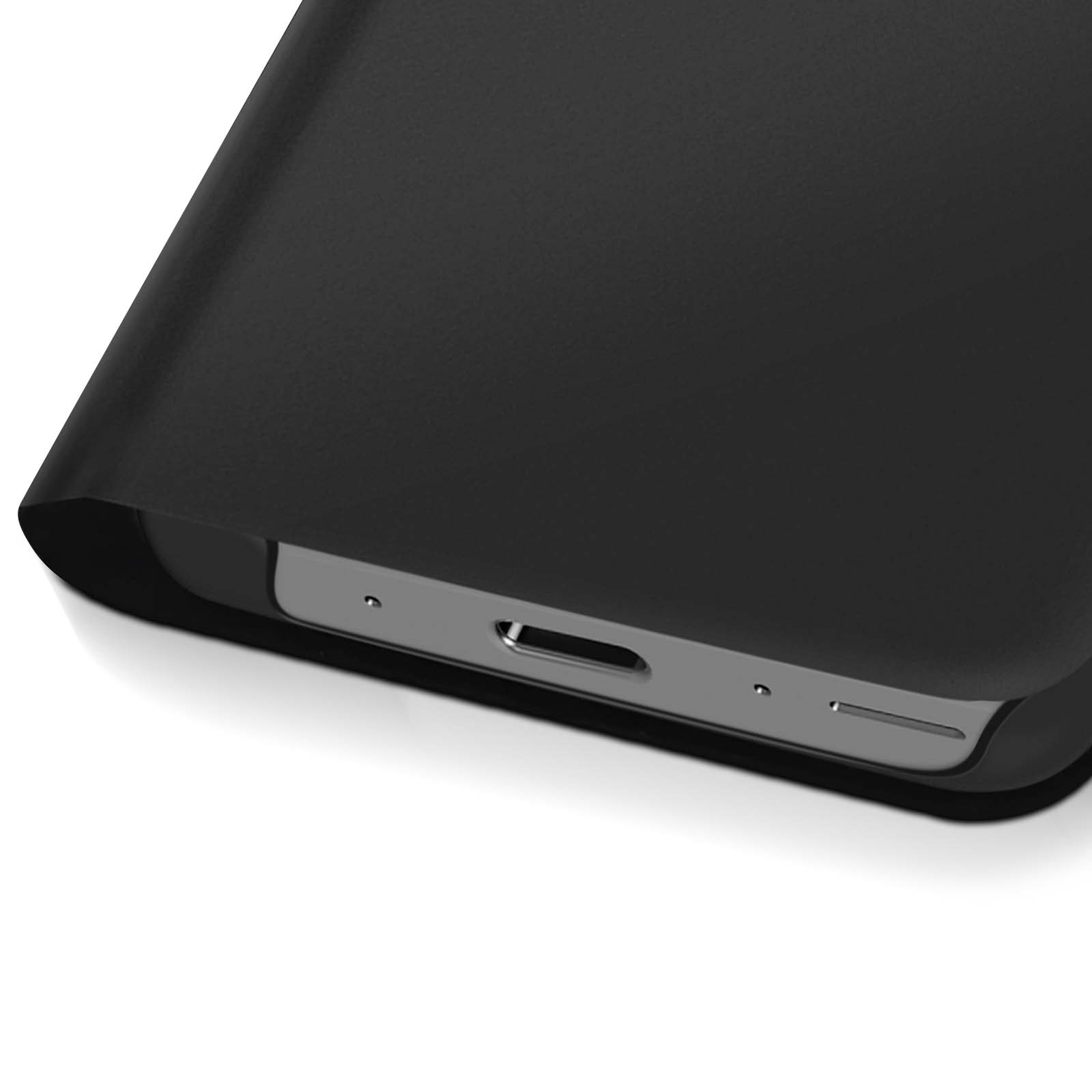 Close-up van een zwarte smartphone met oplaadpoort. De telefoon ligt op een wit oppervlak.