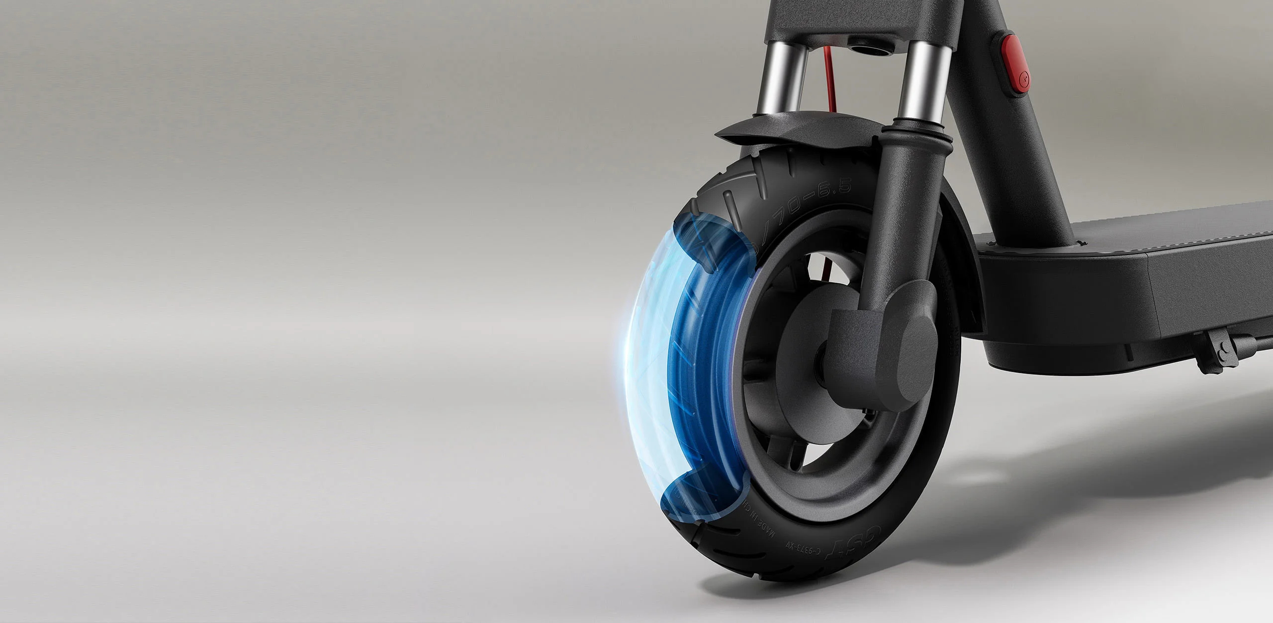 Ruota anteriore dello scooter elettrico, con effetti blu luminosi, su sfondo grigio, che mostra i dettagli del pneumatico.