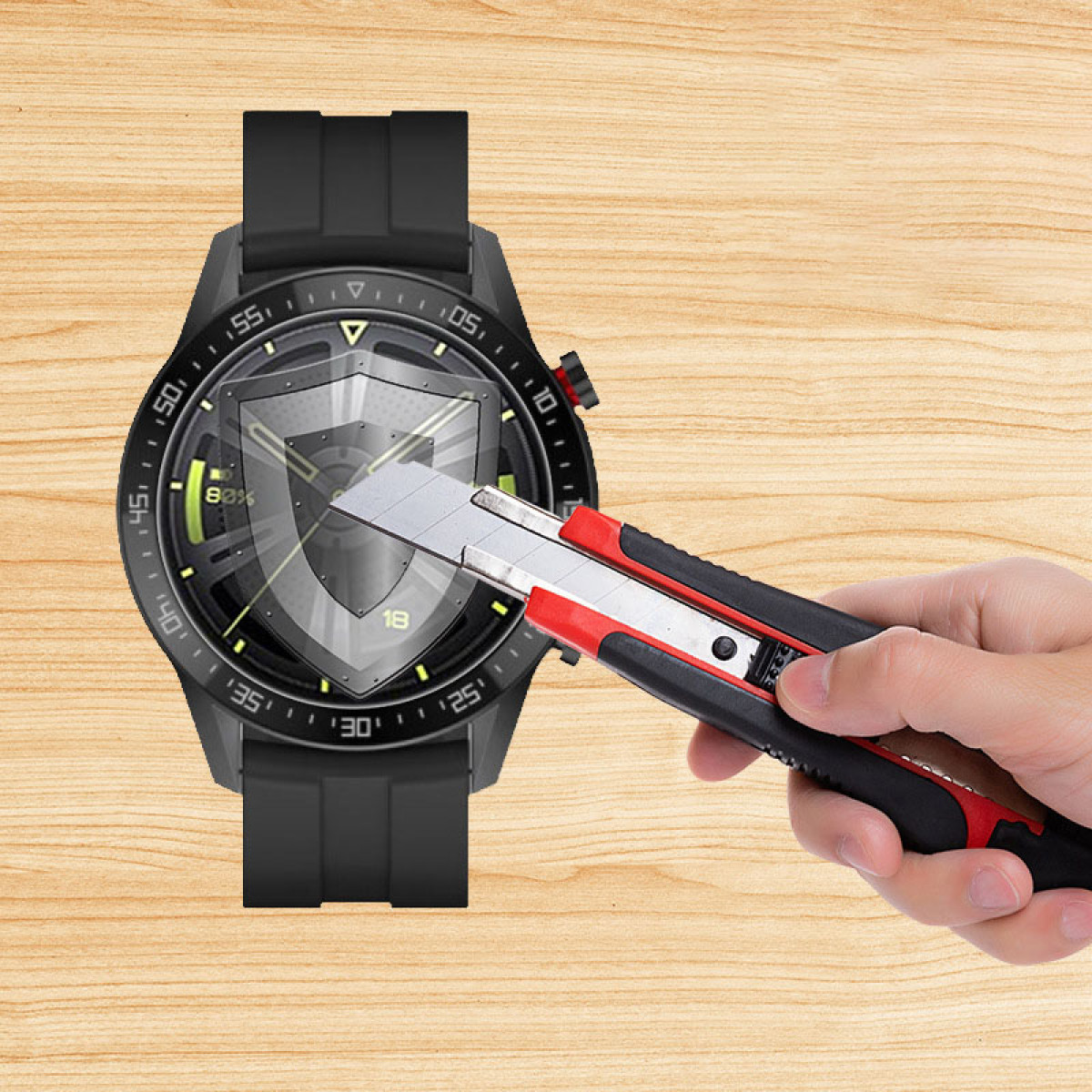 Uno smartwatch nero tagliato con un taglierino su una superficie di legno. Lo schermo è acceso.